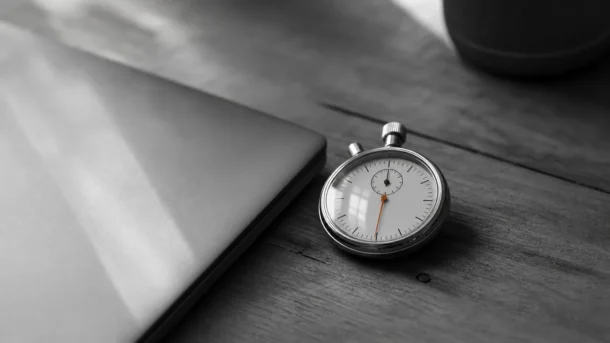 Un chronomètre posé près d'un ordinateur fermé, pour évaluer un contenu IA par la mesure plutôt que par le débat